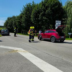 An der Kreuzung stehen die verunfallten PKW, sowie 2 Feuerwehrautos, zwei Rettungsautos und mehrere Passanten