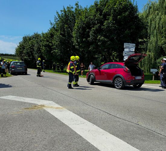 An der Kreuzung stehen die verunfallten PKW, sowie 2 Feuerwehrautos, zwei Rettungsautos und mehrere Passanten